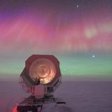 Ein riesiges Teleskop einer US-amerikanischen Forschungsstation am Südpol vor dem Hintergrund spektakulärer Polarlichter.
