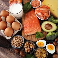 Proteinreiche Lebensmittel wie Fisch, Nüsse, Eier und Linsen auf einem Tisch