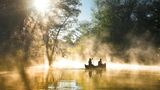 Menschen sitzen in einem Boot auf einem Fluss