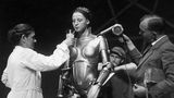 Frau in Roboter-Kostüm bekommt etwas zu trinken