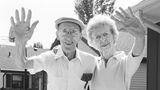 A man and a woman are waving goodbye