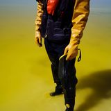 Eine Person steht in gelbgefärbtem Wasser