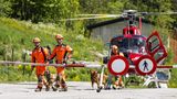 Rettungskräfte steigen mit Hunden aus einem Hubschrauber