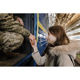 Frau hält Hand ihres Mannes, der in einen Zug steigt