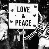 Ein Mann und eine Frau halten ein Schild mit der Aufschrift "Love & Peace"