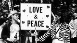 Ein Mann und eine Frau halten ein Schild mit der Aufschrift "Love & Peace"