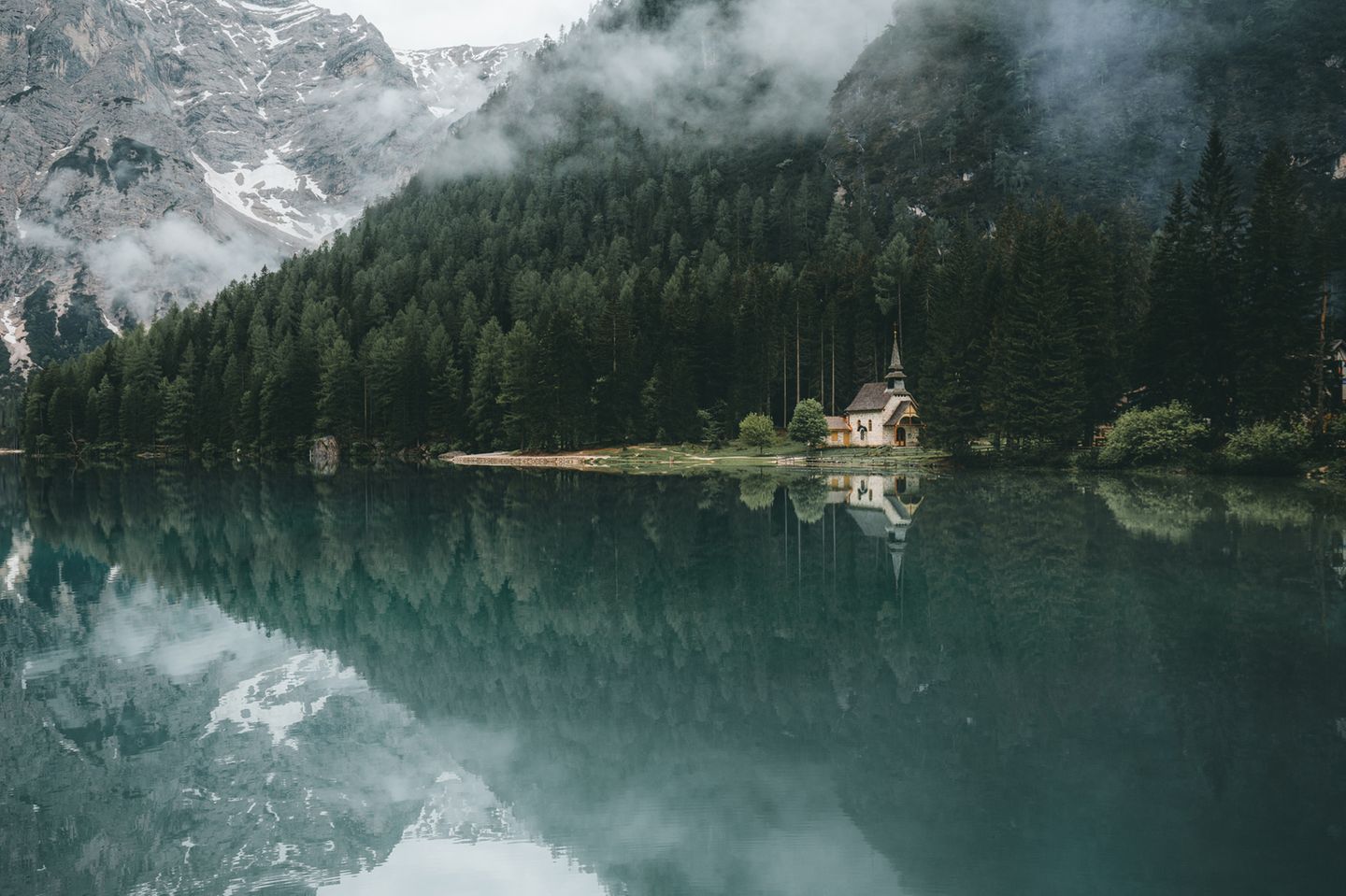 Der smaragdgrüne Pragser Wildsee ist ein echtes Naturwunder. Im stillen Wasser spiegelt sich eine kleine Kapelle.