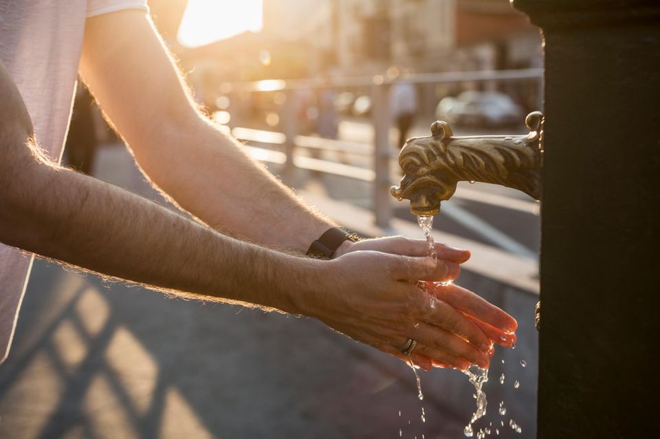 Hände waschen an einem Stadtbrunnen 1.4993