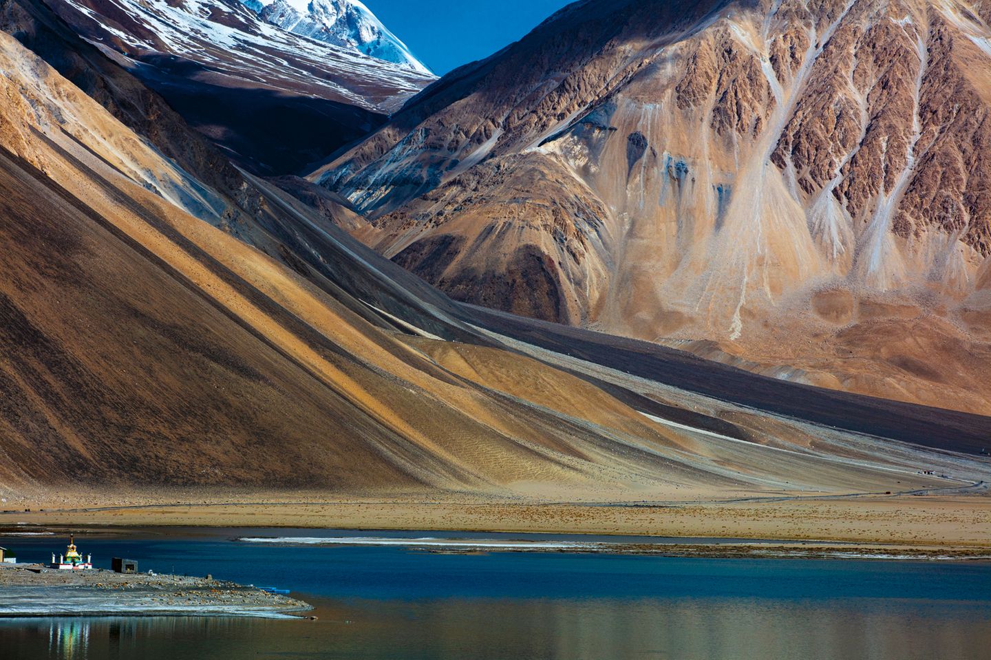 Umgeben von schroffen Felsen und schneebedeckten Gipfeln: Der 134 Kilometer lange Pangong-See in der Hochgebirgswüste des Himalaya wird ausschließlich von Regen- und Schmelzwasser gespeist. Man bezeichnet ihn auch als "See der wechselnden Farben", weil er je nach Sonneneinstrahlung blau oder grünlich schimmert.