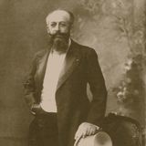 Georges Nagelmackers (Ein Mann mit Halbglatze und langen Bart steht im Frack angelehnt an einen Stuhl)