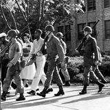 Soldaten der Nationalgarde eskortieren einen schwarzen Schüler aus der Schule in Little Rock