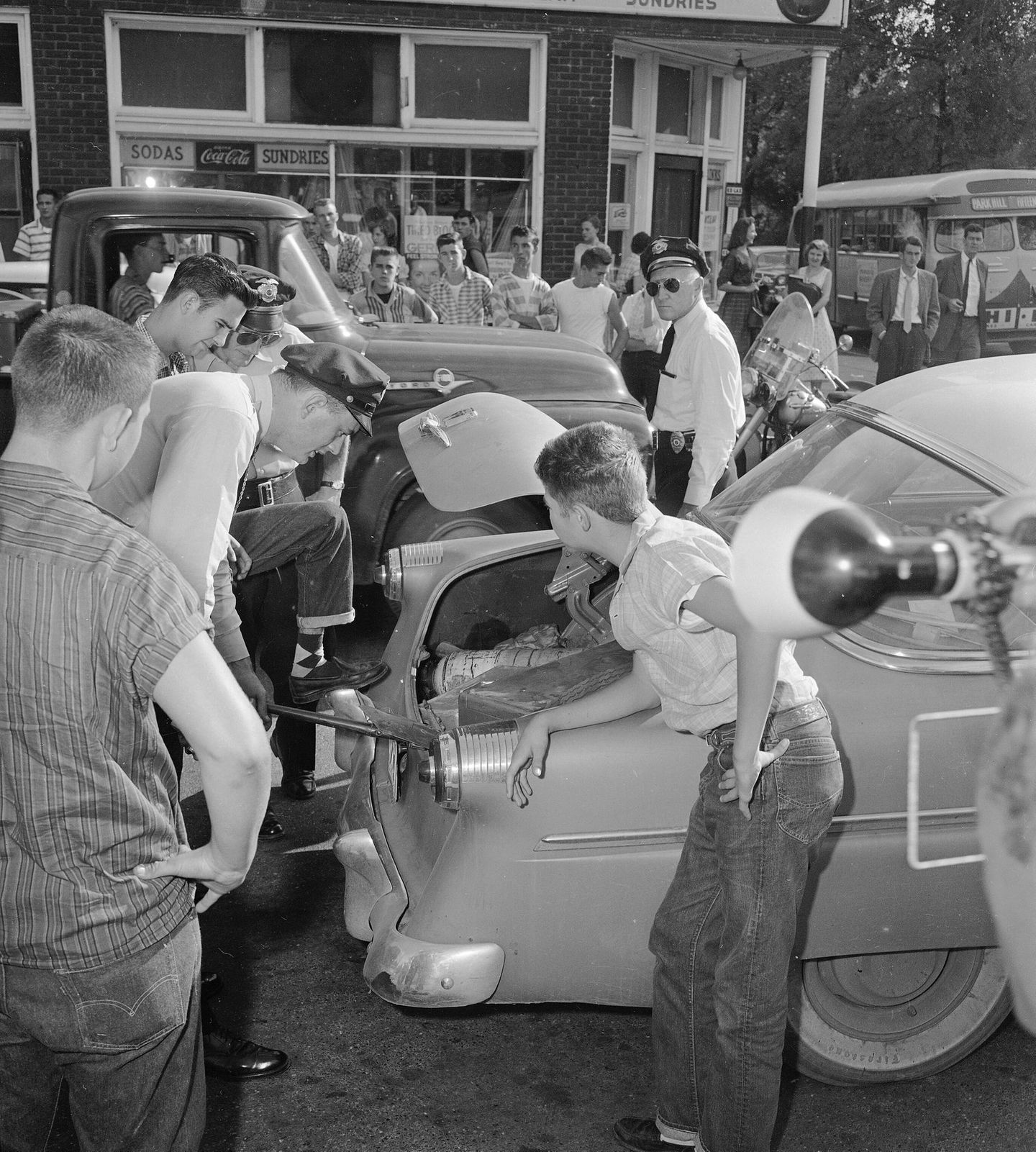 Polizisten schauen in den Kofferraum eines Autos