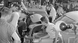 Polizisten schauen in den Kofferraum eines Autos