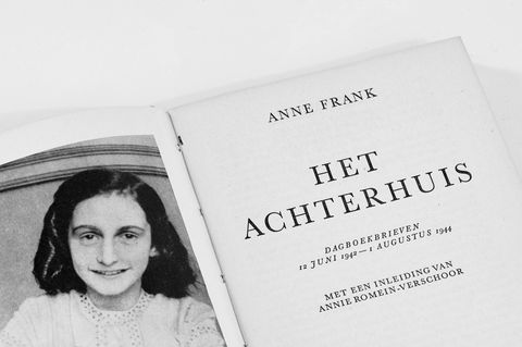 Titelseite einer niederländischen Ausgabe des Tagebuchs der Anne Frank, darauf links ein Foto von ihr: als lächelndes Mädchen