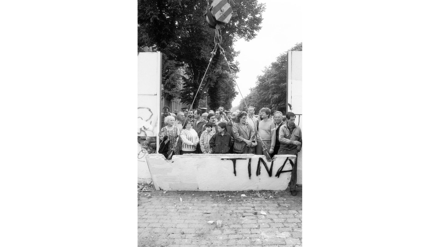 Zum Abheben: Nach Jahrzehnten der Teilung bricht ein Bagger ein Stück aus der Berliner Mauer an der Bernauer Straße. Um einen Blick auf die andere Seite zu werfen, sind Hunderte Neugierige gekommen