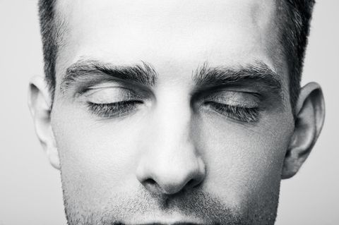 Mann atmet und hat die Augen geschlossen