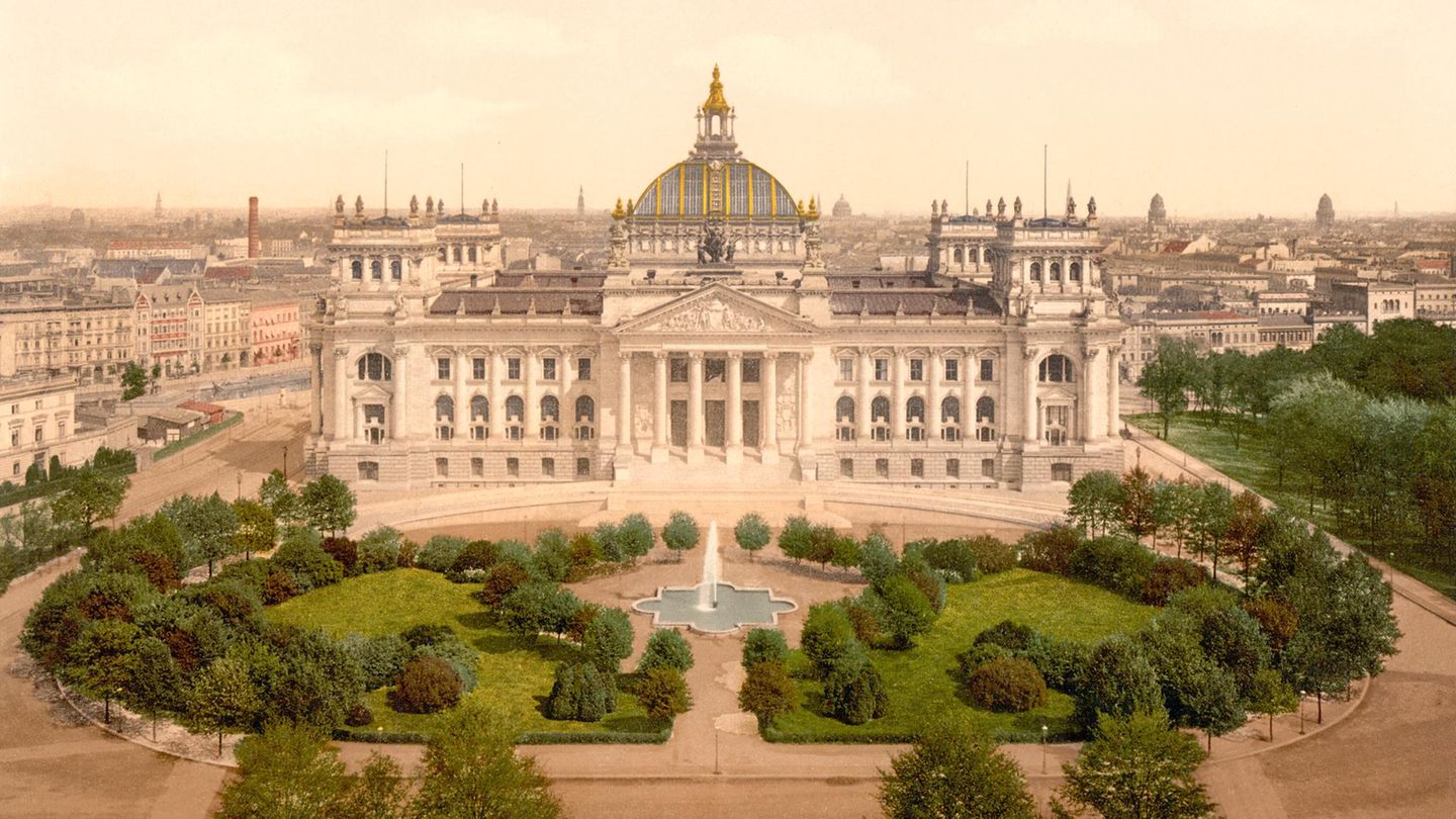 Von Gärten umgeben Reichstagsgebäude mit Parkanlage und Springbrunnen davor, historische Ansicht