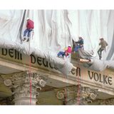 Gewerbekletterer seilen sich vom Reichstagsgebäude ab, um Stoffbahnen abzurollen. Dahinter der Schriftzug: dem deutschen Volke