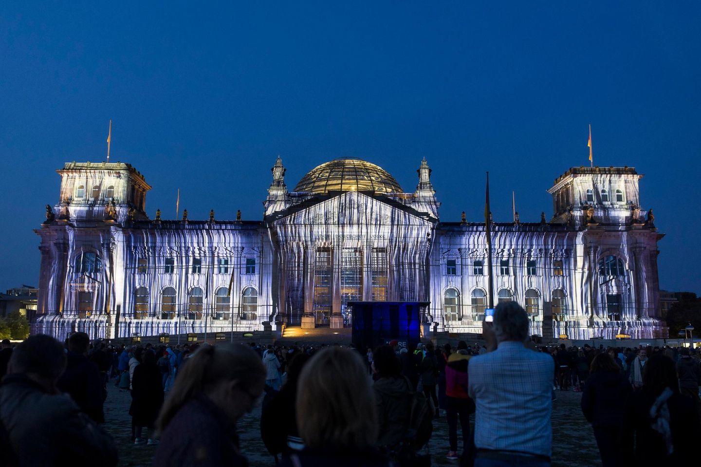 Bilder von Stoffbahnen werden 2025 auf das Reichstagsgebäude projiziert