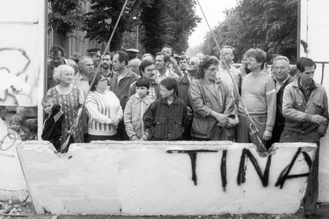 Zum Abheben: Nach Jahrzehnten der Teilung bricht ein Bagger ein Stück aus der Berliner Mauer an der Bernauer Straße. Um einen Blick auf die andere Seite zu werfen, sind Hunderte Neugierige gekommen