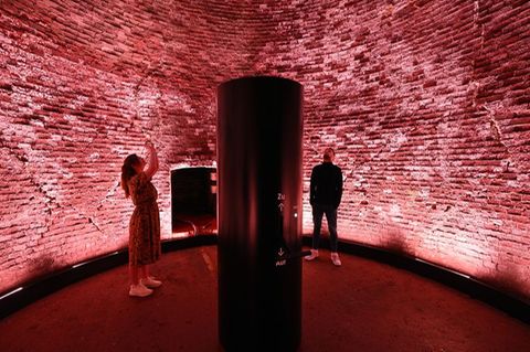 Höllenmaschine mit Lichtkunst: Der 98 Meter hohe Schornstein der Kokerei Zollverein leuchtet rot als Teil des erweiterten Denkma
