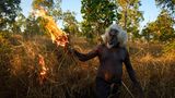 Ein Aborigine in West Arnhem Land legt Feuer, und das mit voller Absicht: