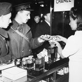 Britische Soldaten an einem Chanel-Stand 1939 in Paris. Nach Ausbruch des Zweiten Weltkriegs schließt Chanel ihre Schneiderei, entlässt alle Näherinnen. Nur ihren besten Geldbringer, das Parfum Chanel No 5, verkauft sie weiter. Unter der deutschen Besatzung Frankreichs kollaboriert sie mit den Nationalsozialisten, beginnt eine Liebschaft mit einem SS-Mann, der als Agent arbeitet, spioniert auch selbst für die Deutschen. Nach der Befreiung Frankreichs wird sie 1944 verhaftet, bleibt aber nur wenige Stunden in Haft. Wie es ihr gelingt, sich so schnell aus den Fängen der Justiz zu winden, ist bis heute unklar.   