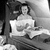 Eine Stewardess serviert auf einem Pan-Am-Transatlantikflug 1952 das Frühstück. Der Komfort lässt in Maschinen wie der Boeing 377 Stratocruiser wenig zu wünschen übrig: Dort lassen sich Sitze in Betten verwandeln und gibt es Waschräume für die betuchte Kundschaft, um sich für den perfekten Auftritt am Zielort vorzubereiten