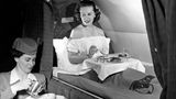 Eine Stewardess serviert auf einem Pan-Am-Transatlantikflug 1952 das Frühstück. Der Komfort lässt in Maschinen wie der Boeing 377 Stratocruiser wenig zu wünschen übrig: Dort lassen sich Sitze in Betten verwandeln und gibt es Waschräume für die betuchte Kundschaft, um sich für den perfekten Auftritt am Zielort vorzubereiten