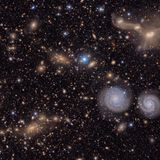 Eines der ersten Bilder, die das Team des gerade in Betrieb genommenen Vera C. Rubin Observatory der Öffentlichkeit präsentierte. Es zeigt einen Ausschnitt des Virgo-Galaxiehaufens, der bis zu 2000 Galaxien umfasst. Sterne in der Milchstraße funkeln blau, nahe Spiralgalaxien erscheinen weiß. Weit entfernte, elliptische Galaxien leuchten gelb und orange. Anhand der Farben des Lichts können Forschende ihre Entfernung bestimmen. Tatsächlich sehen wir nur einen kleinen Ausschnitt der eigentlichen Aufnahme. Das Bild, das die Kamera des Observatoriums auf ihren Sensor bannt, ist 50-mal größer. Um alle Feinheiten mit bloßem Auge betrachten zu können, bräuchte es einen hochauflösenden Bildschirm von der Größe eines Basketballfelds. Nur so ließen sich Details wie die verschmelzenden Galaxienpaare oben rechts im Bild erkennen.