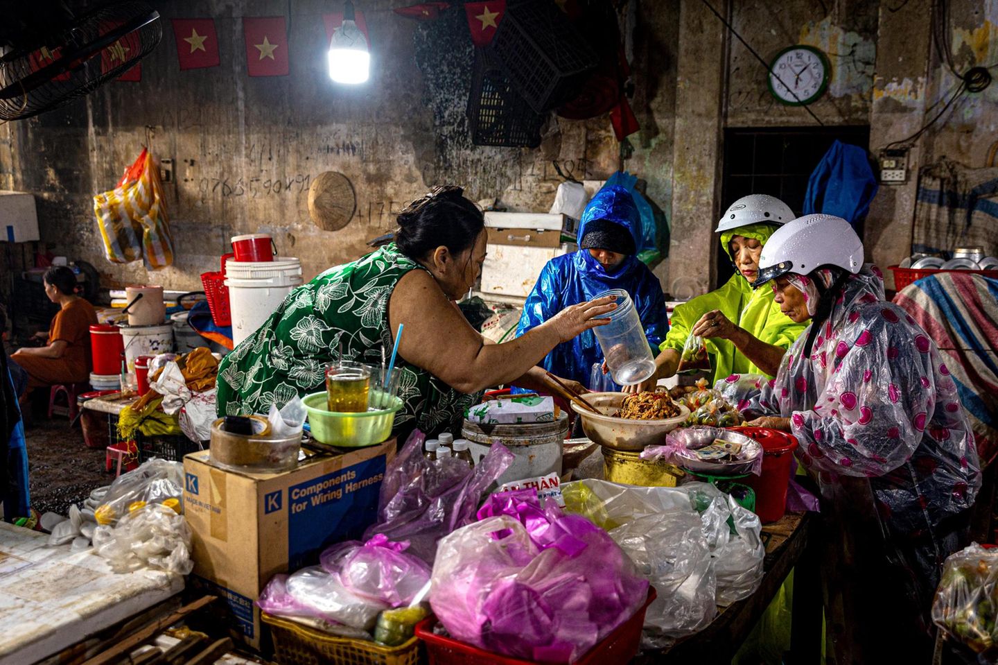 Sechs Uhr morgens, Wolkenbruch in der vietnamesischen Küstenstadt Hoi An. Die Frauen haben sich dennoch zum Zentralmarkt durchgekämpft und verpacken nun ihre Einkäufe.