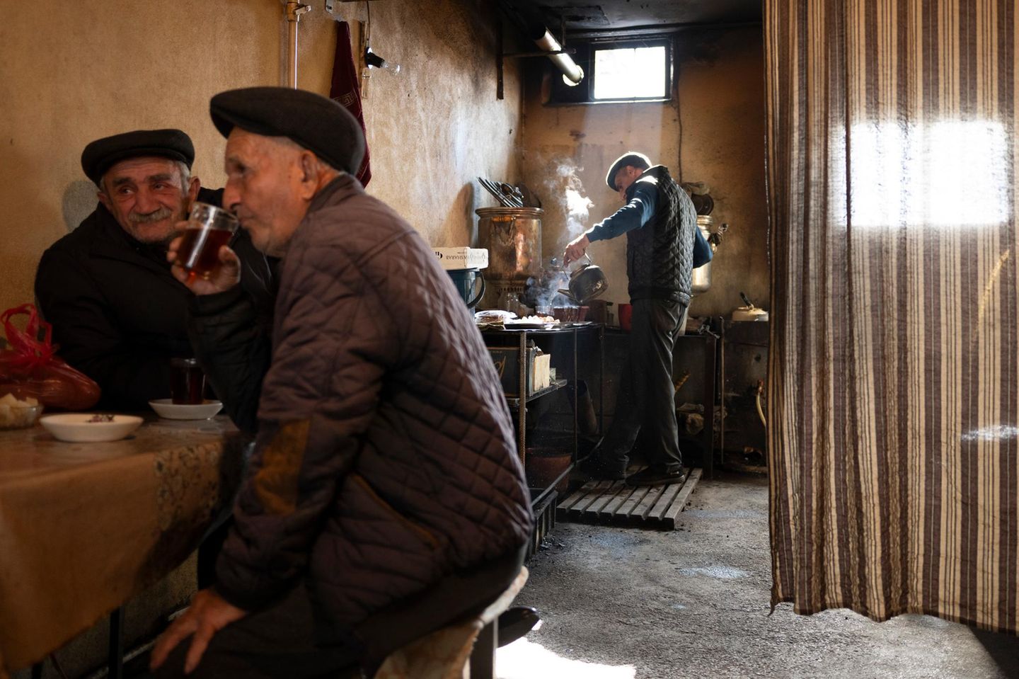 Nur wenige Schritte vom bunten Treiben auf dem Basar von Sheki entfernt, haben sich diese Männer ins Innere eines Teehauses zurückgezogen. Schwarztee ist in Aserbaidschan ein fester Bestandteil des täglichen Lebens und wird traditionell in einem Samowar aufgebrüht.