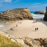Touristen gehen am Playa de las Catedrales spazieren