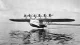 Die "Do X", das mit 48 Meter Spannweite bei seiner Fertigstellung um 1930 größte Flugzeug der Welt, hebt vom Bodensee ab. Mit dem gewaltigen Flugschiff, das mehr als 150 Reisenden Platz bietet, will der Ingenieur Claude Dornier vom Passagiergeschäft profitieren, das ab den 1920er Jahren stetig wächst. Das Modell erweist sich zwar als unwirtschaftliche Vision – doch Experimente wie dieses treiben den technischen Fortschritt immer weiter voran