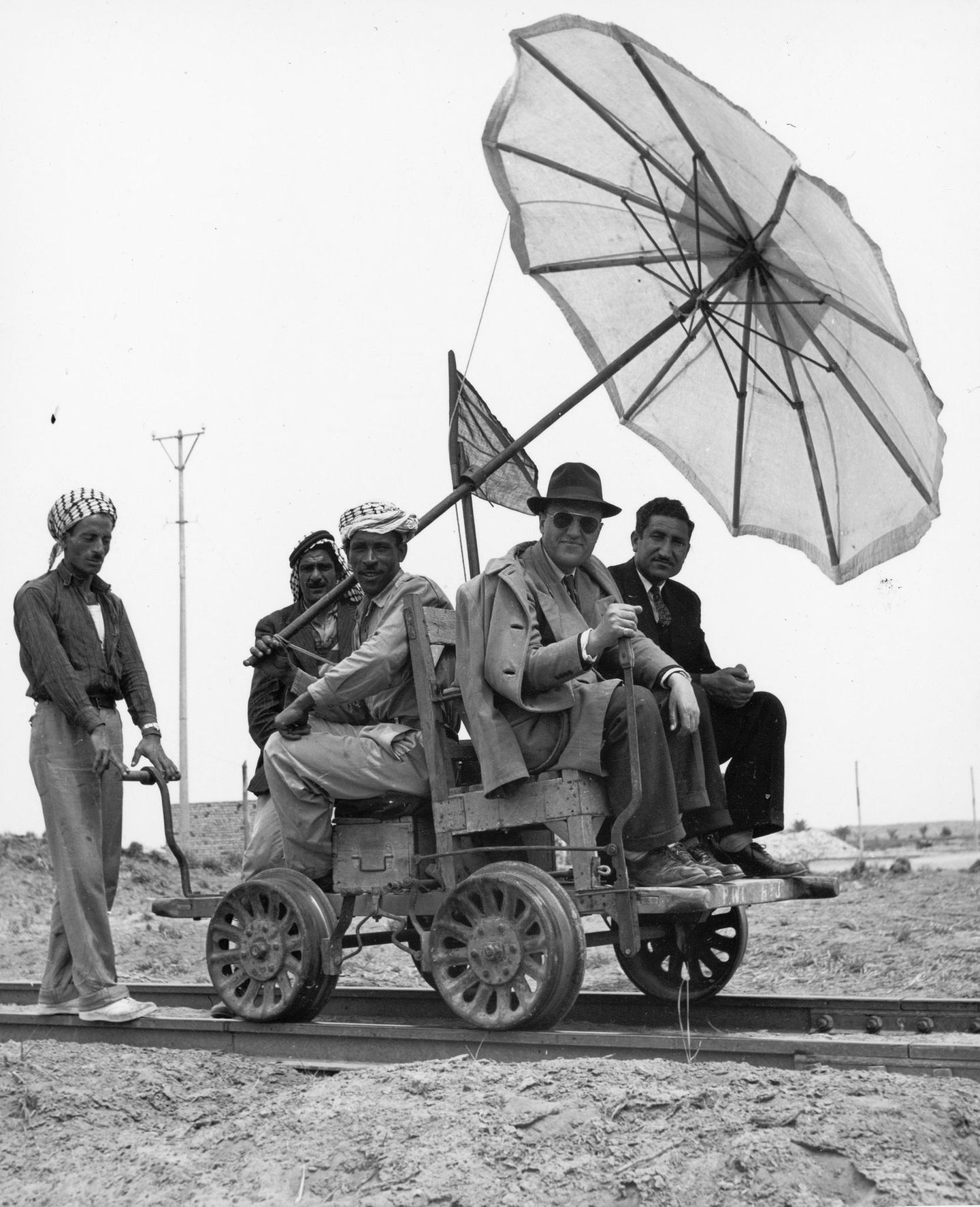 Vier Männer sitzen auf Schienen-Wagen