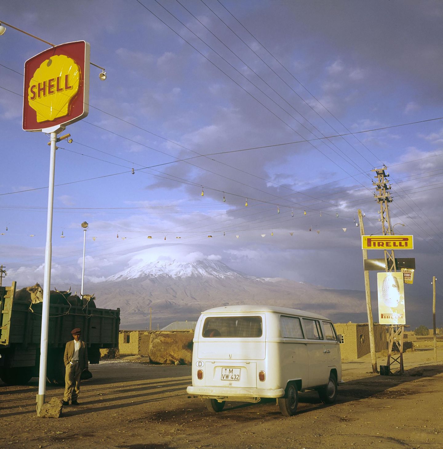 Bulli an einer Tankstelle vor Berg