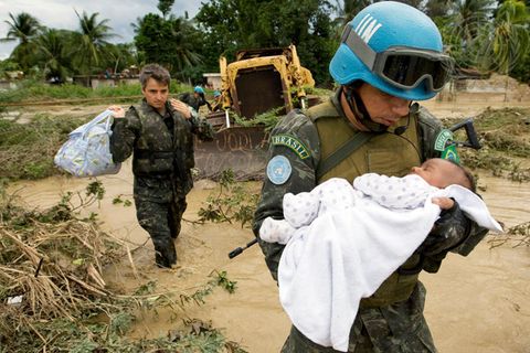 Nach einem Tropensturm in Haiti bringt ein brasilianischer UN-Soldat ein Baby in Sicherheit