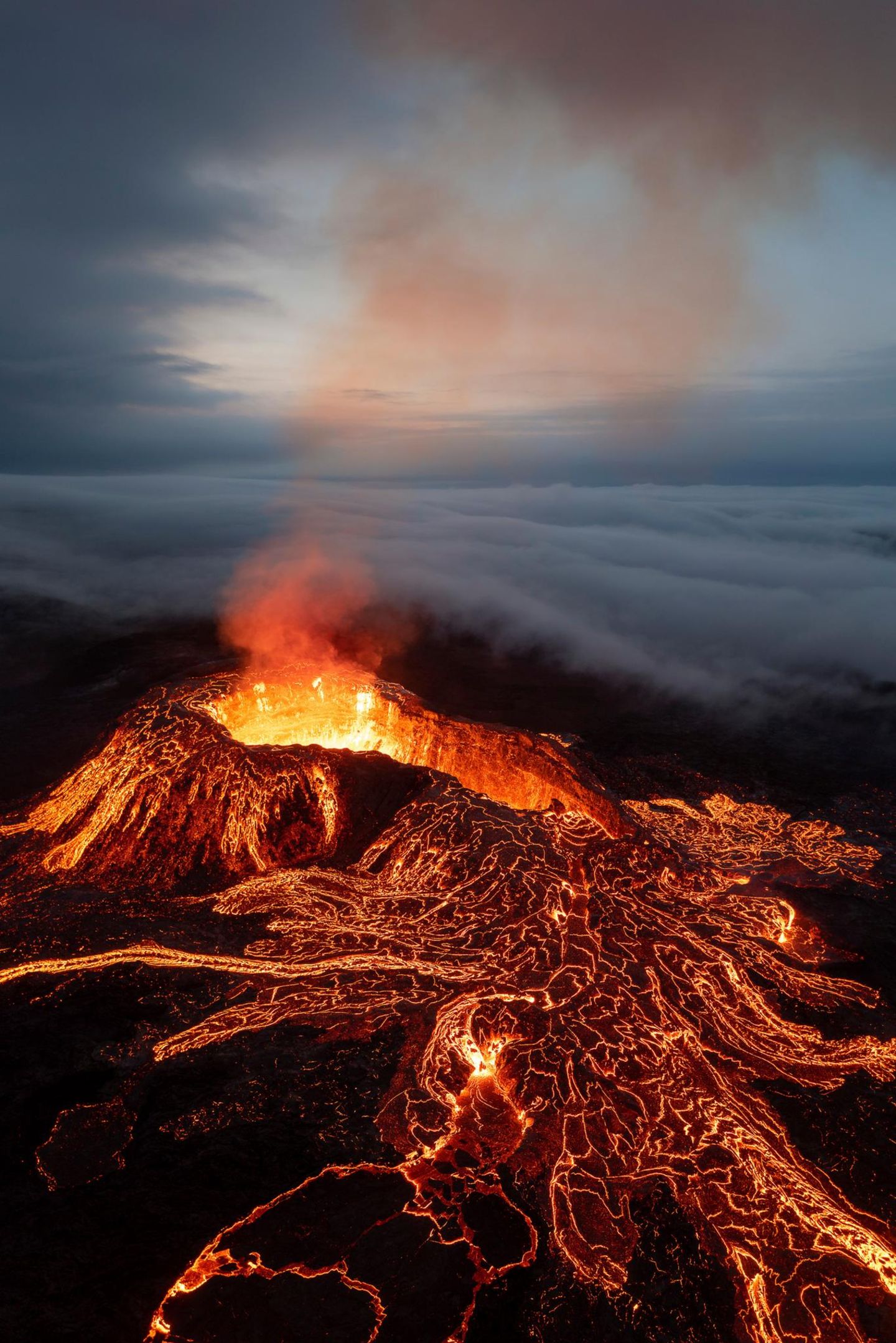 Fließendes Feuer Als 2021 auf Island der Vulkan Geldingadalir ausbricht, ergießt sich die Lava wie ein magisch glühender Fluss über das dunkle Vulkangestein. Eine dichte Decke aus Wolken schiebt sich währenddessen über den brodelnden Vulkankrater. Jeroen Van Nieuwenhove hat den Moment eingefangen.