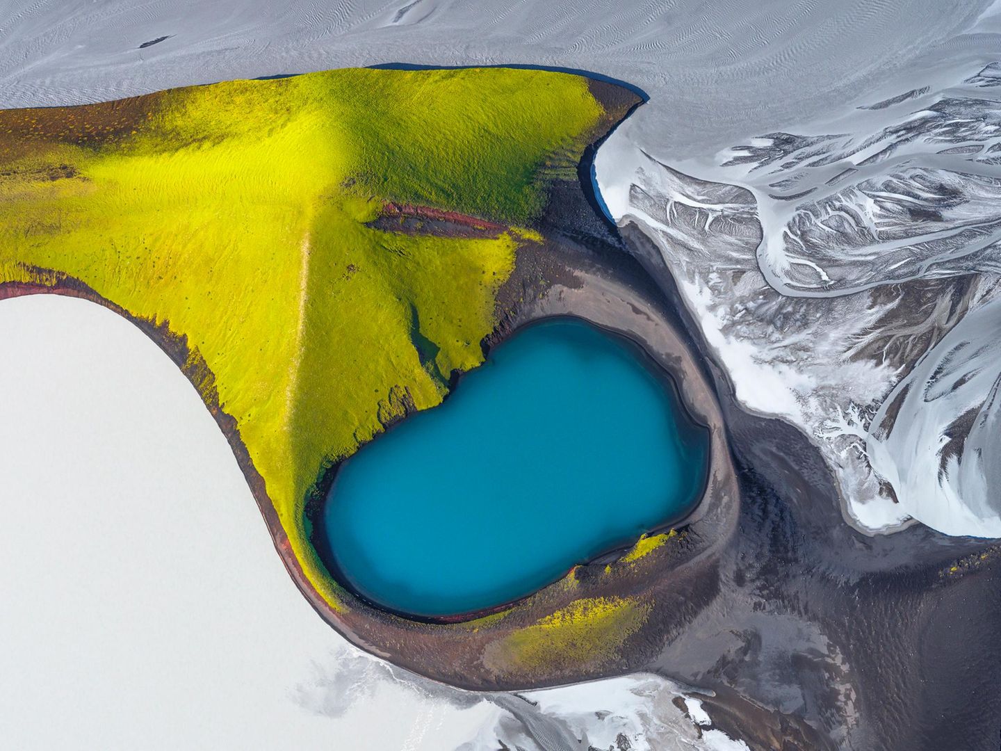 Farbtupfer Im südlichen Hochland Islands taucht der Herbst die Natur in Farben, so kräftig wie aus dem Malkasten: Das satte Blau eines Kratersees kontrastiert mit dem leuchtenden Grün moosbewachsener Berghänge und dem schlammigen Grau des Flusses Skaftá, der sich aus einem Gletscherlauf speist. Die Aufnahme von Andro Loria gehört zu den 100 besten Fotografien des "International Aerial Photographer of the Year".