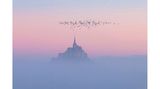 Die Morgensonne taucht die aus dem Nebel aufsteigende Felseninsel Mont-Saint-Michel in rosafarbenes Licht. Die Insel mit dem gleichnamigen Dorf liegt etwa einen Kilometer von der Küste entfernt im Wattenmeer der Normandie und zählt zum Weltkulturerbe der UNESCO.