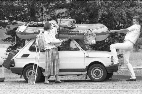 Paar und überladenes Auto in der Urlaubszeit1987