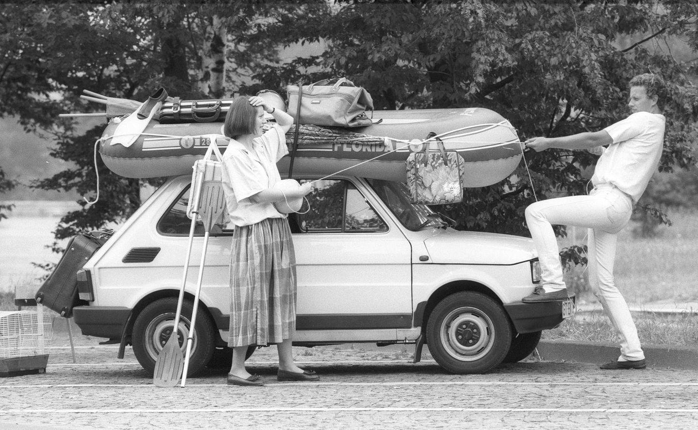 Paar und überladenes Auto in der Urlaubszeit1987