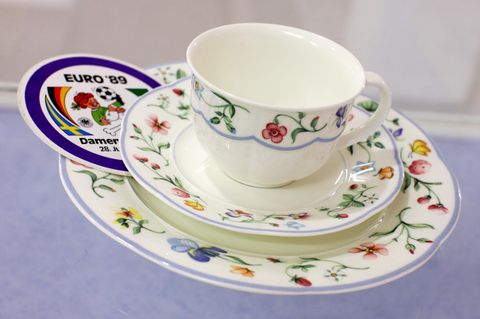 Geblümtes Porzellan der Serie "Mariposa", daneben ein Sticker mit der Aufschrift "Euro '89"