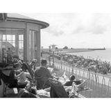 Ein friedlicher Moment am Meer: Die Sonne wärmt die Terrasse der Lesehalle im Seebad Büsum. Aus dem Liegestuhl schweift der Blick über die Reihen von Strandkörben – dahinter liegt die Einfahrt zum Fischereihafen.