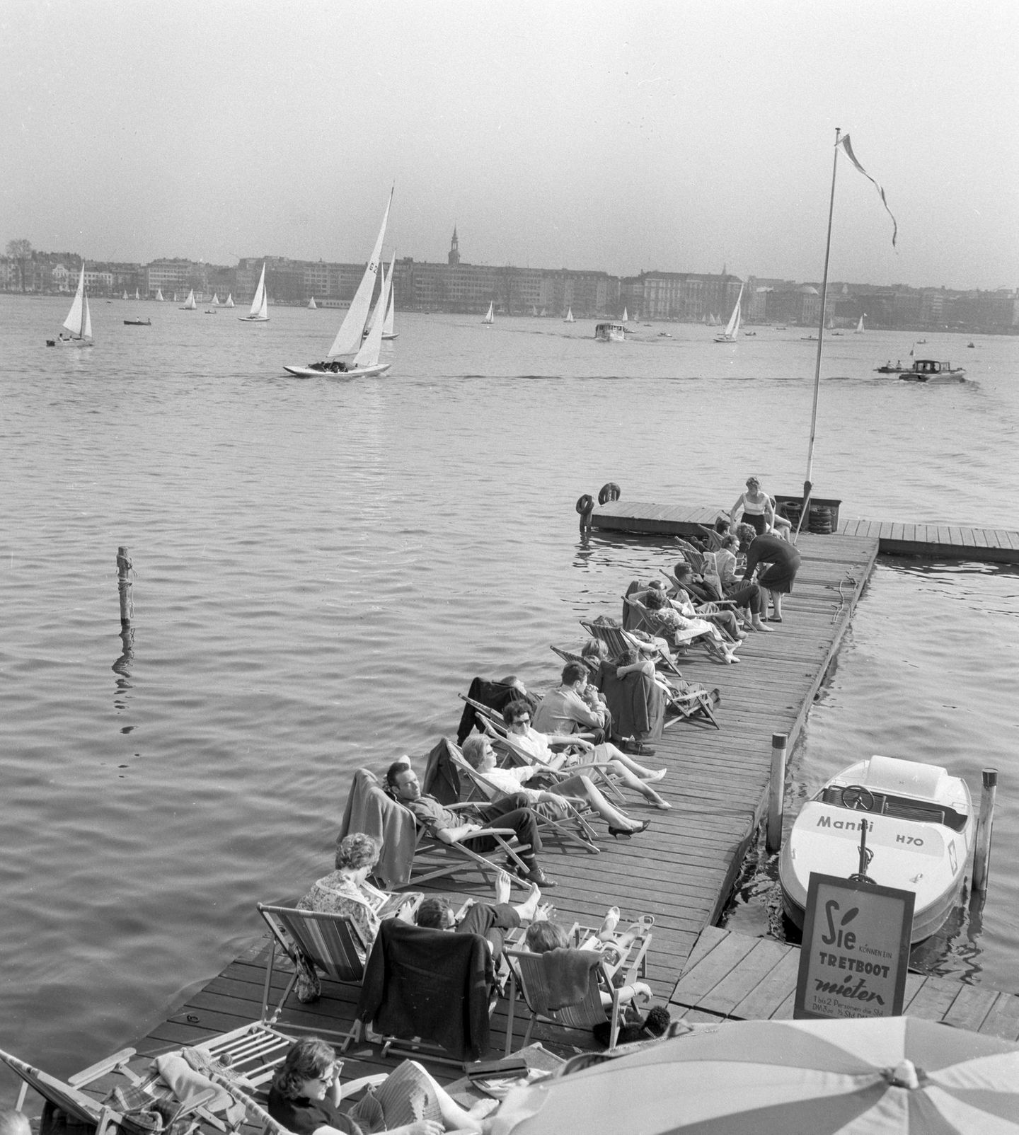 Hamburg, 1962 Sonnige Stunden an der Außenalster: Am 24. April 1962 genießen zahlreiche Hamburger das warme Frühlingswetter. Die Terrassen der Cafés sind belebt, Liegestühle am Wasser begehrt – kaum ein Platz bleibt frei. Wer will, kann aufs Wasser: Eine oder zwei Personen zahlen drei D-Mark für eine Stunde Tretbootvergnügen.