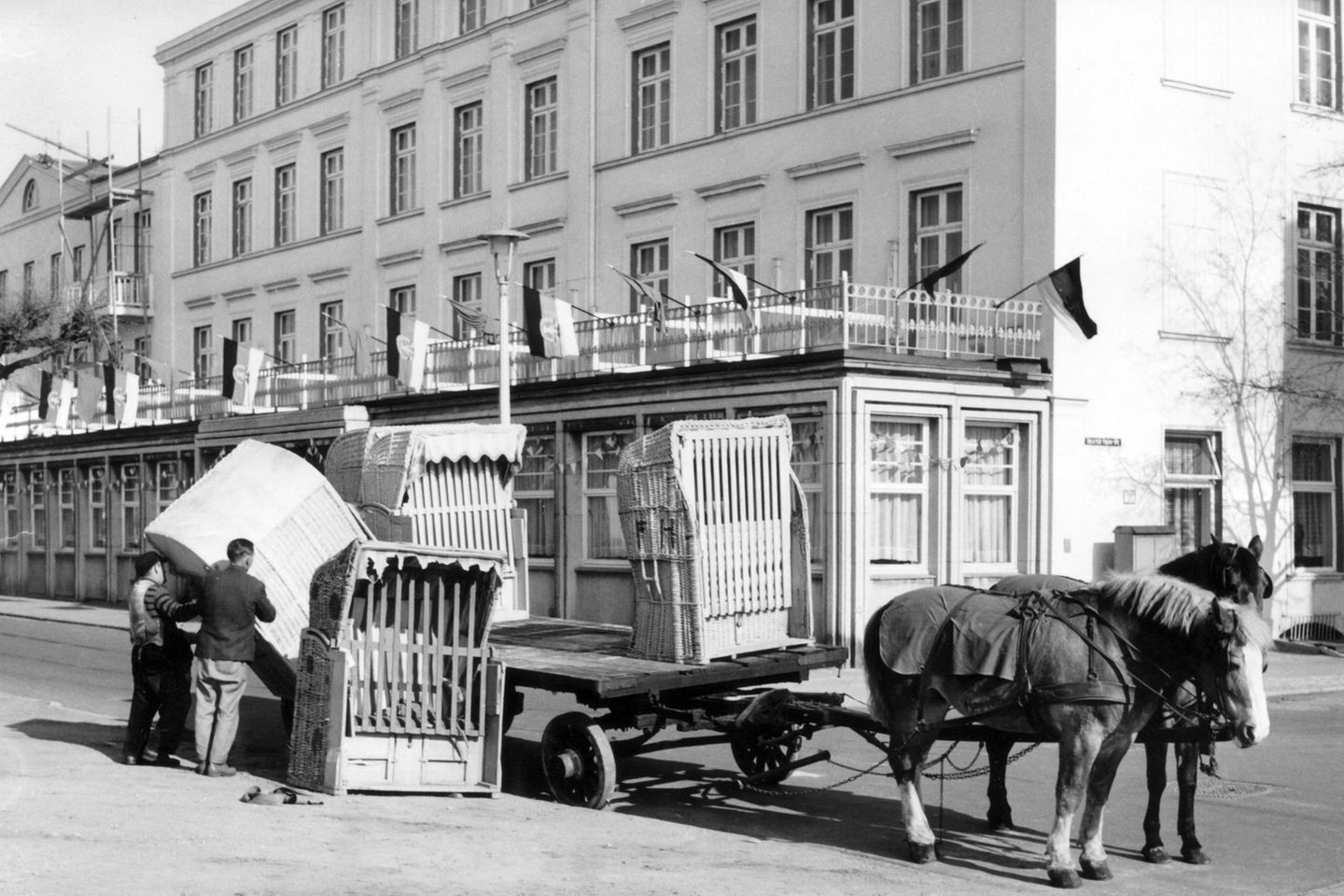 Sommerbeginn in Warnemünde: Arbeiter laden Anfang Mai Strandkörbe von einem Pferdewagen. Die Ostseeküste rüstet sich – in den Seebädern der DDR werden die Strände für die neue Badesaison vorbereitet.