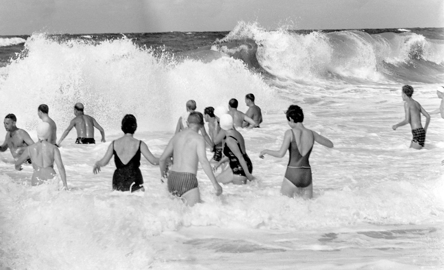 Unverzagt genießen Badegäste den starken Wellengang und die erfrischende Gischt am Strand in Wenningstedt auf der Nordseeinsel Sylt.