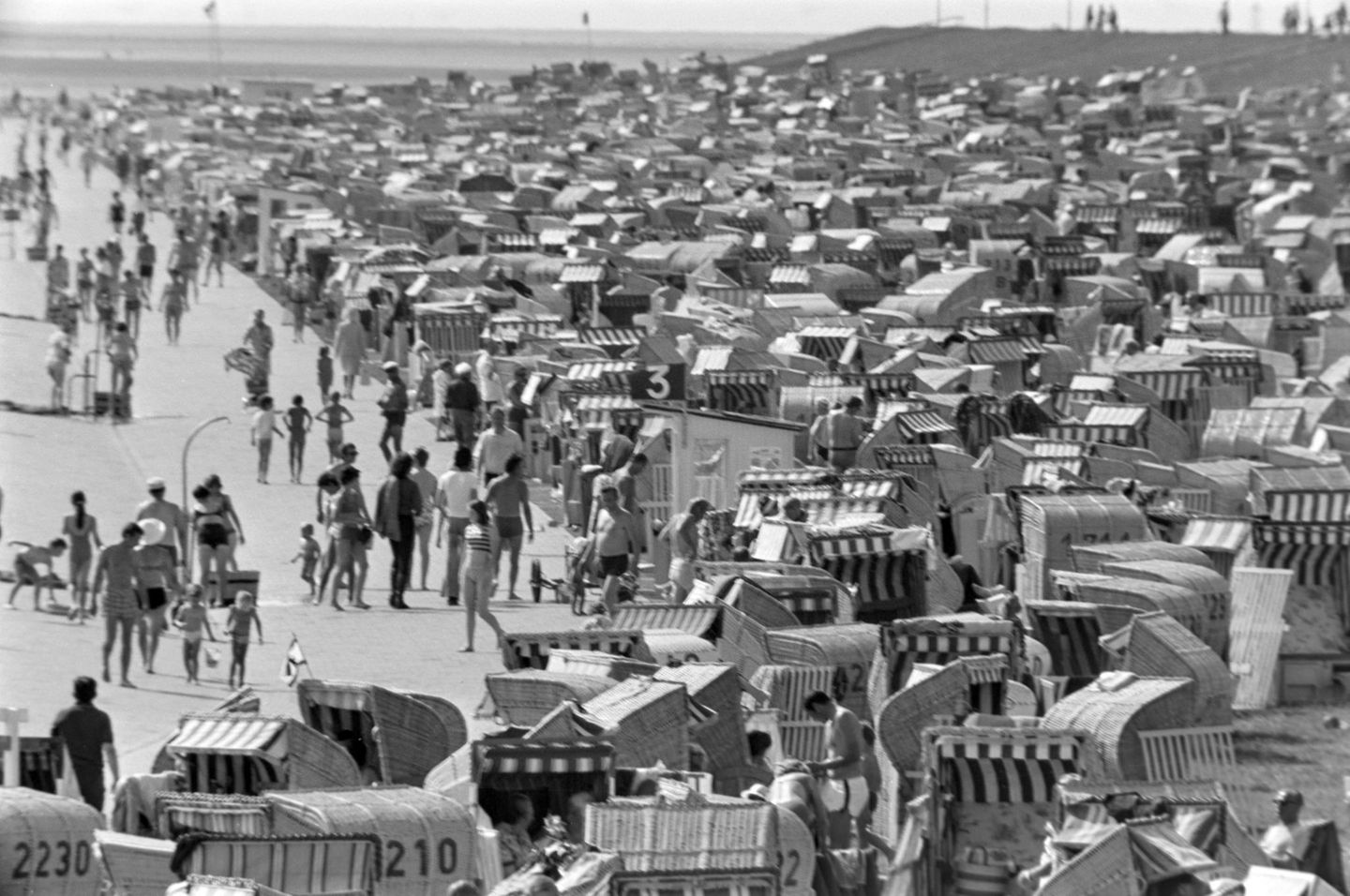 Büsum, 1971 Ein Meer aus gestreiften Markisen und Korbgeflecht: Die Stadtverwaltung von Büsum hat rund 4000 Strandkörbe für die Sommersaison bereitgestellt. Urlauber finden darin Schutz vor Wind und Sonne – und ein Stückchen Privatsphäre am gut gefüllten Badestrand.