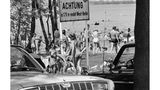 Berlin, 1971 Sommerhitze in einer geteilten Stadt: Westberliner suchen Abkühlung im Glienicker See. Bei mehr als 30 Grad wird das Gewässer im Ortsteil Kladow zur willkommenen Erfrischung. Doch selbst am belebten Badeplatz erinnert ein Schild: Die Grenze ist nah.