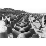 Ein massiver Betongürtel soll auf Sylt den Badespaß bewahren: Die mächtige Struktur verläuft mitten durch das Strandidyll, um bei Hochwasser das Abtragen der Küste zu verhindern. Die vierarmigen Betonklötze (auch Tetrapoden genannt) wurden auf der Insel ab den 1960er-Jahren verbaut. Doch ihr Nutzen blieb umstritten – sie verrutschten bei Sturmfluten, förderten stellenweise den Sandverlust und störten das Landschaftsbild. Umweltfragen und Kritik an ihrer Ästhetik machten sie bald zum Symbol für gescheiterten Küstenschutz. Viele Tetrapoden wurden inzwischen abgeräumt und lagern heute ungenutzt auf der Insel. 2023 erhielten sie neues Leben: Unbekannte sprühten Augen auf die grauen Klötze – aus Küstenschutz wurde Kunst.